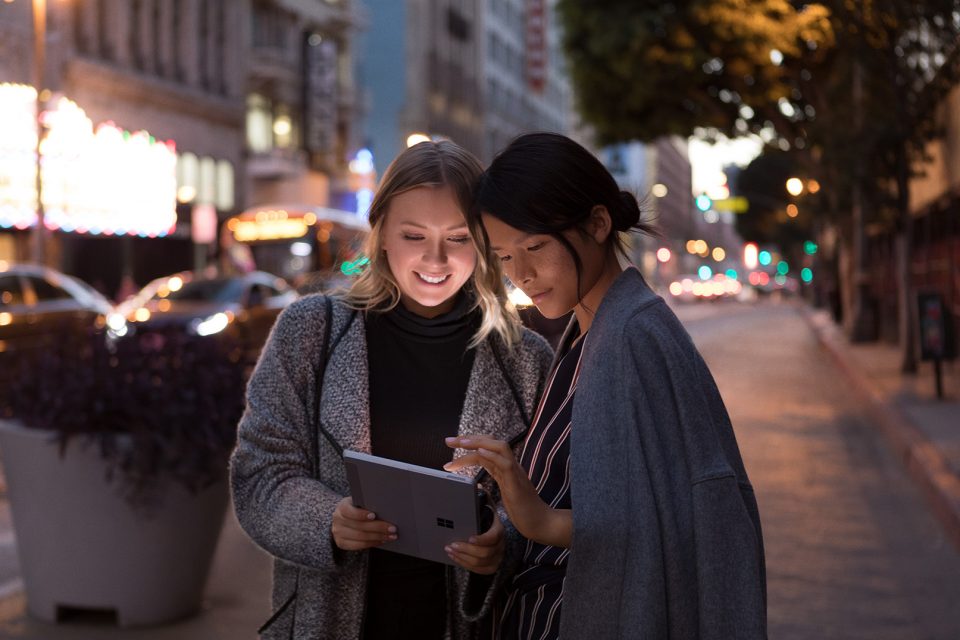 Dos mujeres observan una tablet en la calle