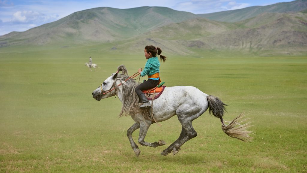 Una niña monta a caballo en un campo abierto en Mongolia