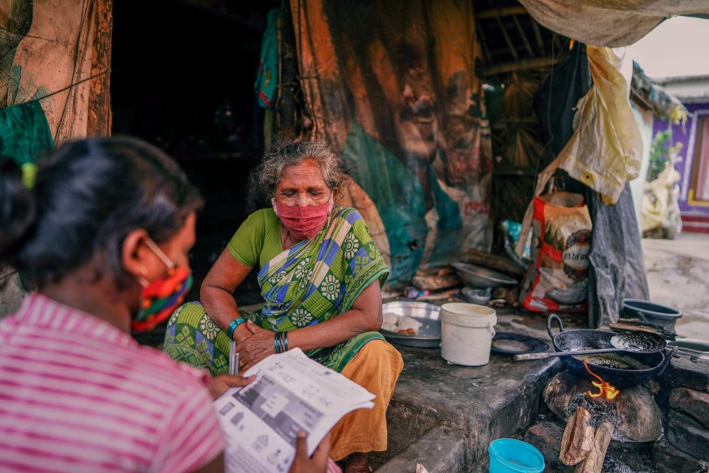 una mujer joven lee un periódico a una mujer mayor