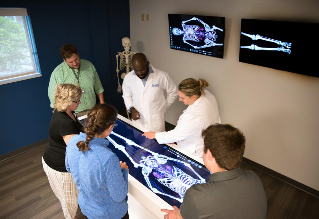 Seis miembros del personal médico miran radiografías