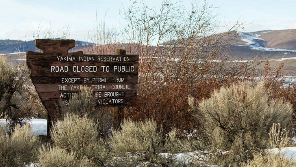 Se muestra un letrero de la Reserva Yakama junto a los arbustos