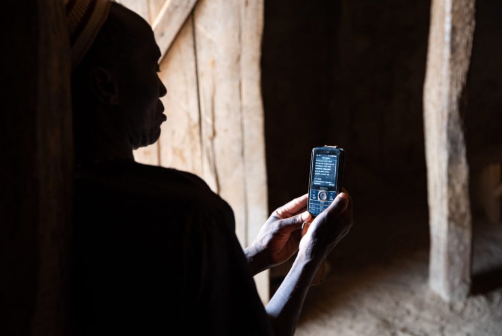 Un residente de Touréla, Malí, realiza un pago de su seguro en su teléfono.