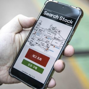 Una persona que sostiene un teléfono muestra la aplicación Search Stock