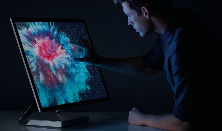Mann der an einem Surface Studio arbeitet und mit AI kommuniziert