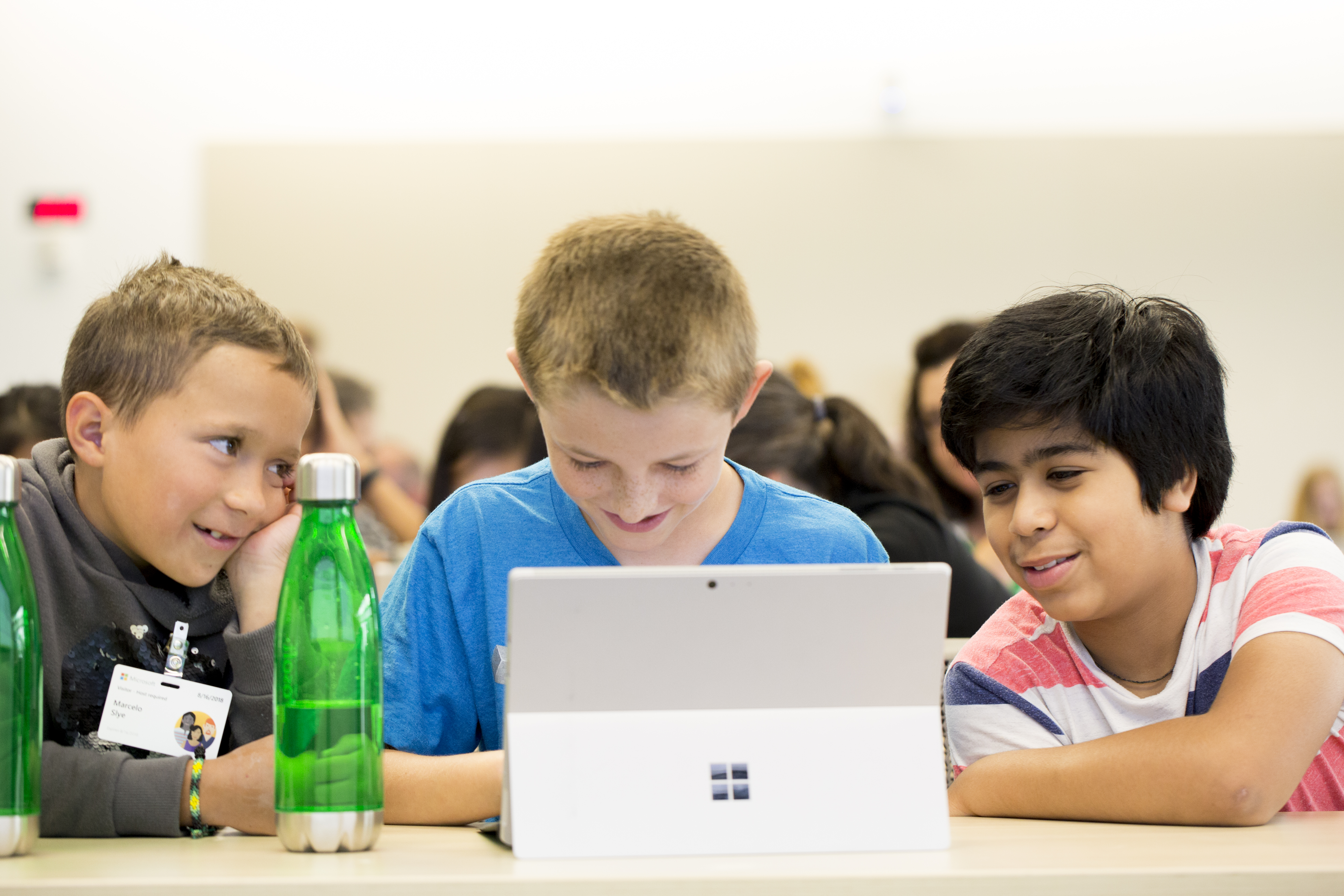 Drei Schulkinder sitzen um den PC