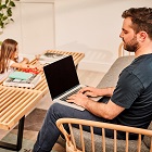 Man with laptop and child playing