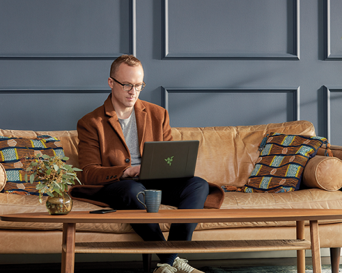 man sitting on couch with laptop