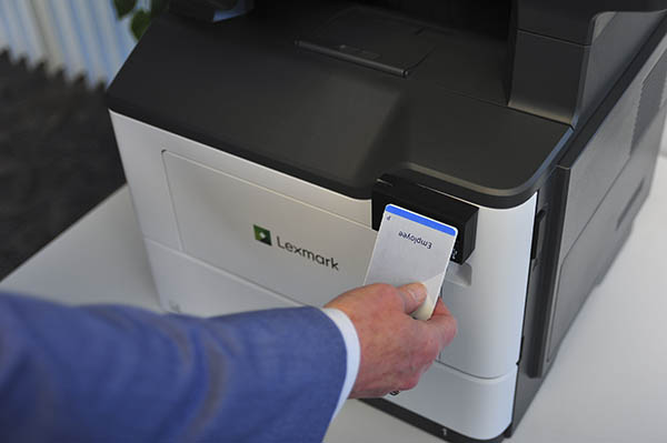 Funcionário faz autenticação com crachá na impressora Lexmark.