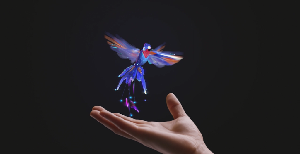 Mão de homem interagindo com um holograma de beija-flor.