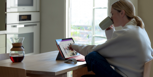 mulher bebendo café sentada e ao computador
