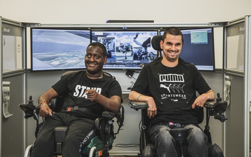 dois homens jovens sentados em cadeiras de rodas sorrindo