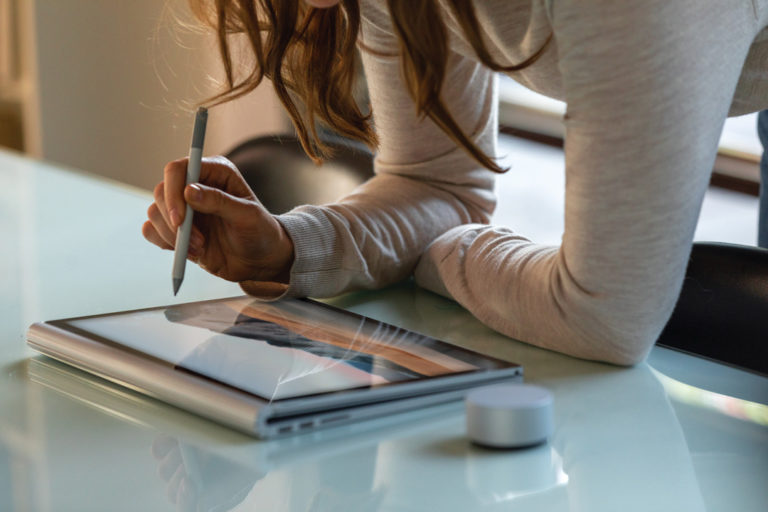 a woman working with a Surface book