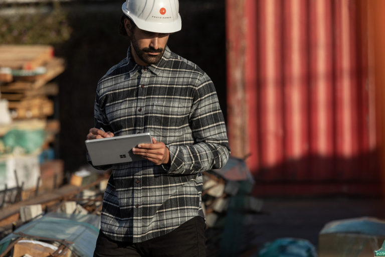 a manufacturing worker holding a Surface Go laptop