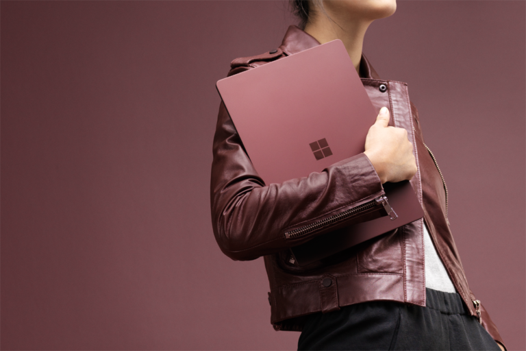 a woman holding a Microsoft Surface laptop