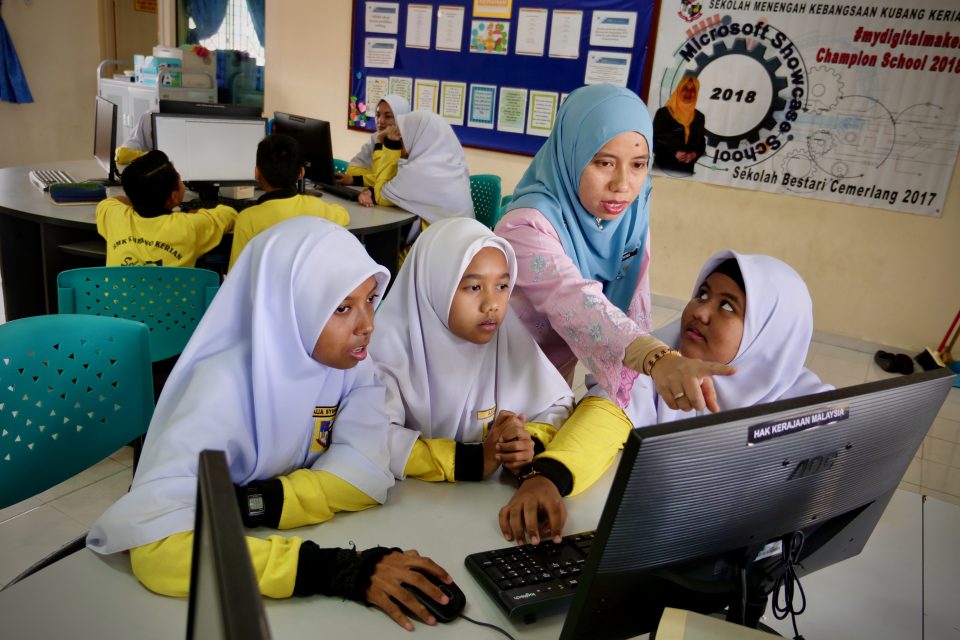 Female students gathering around a computer