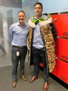 Two men with one weaing a traditional Maori feather cape.