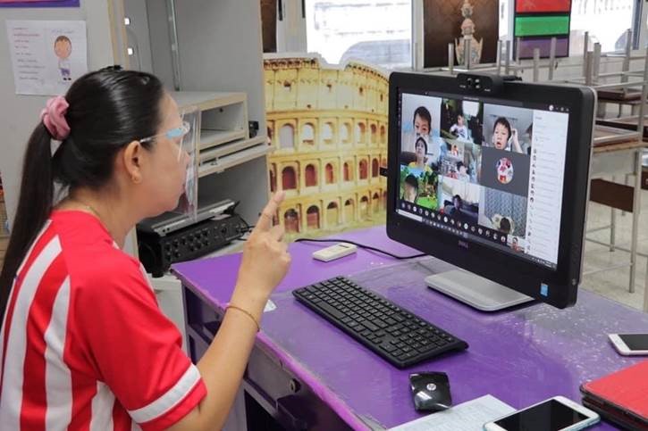 A Thai teacher conducts a lesson with her young elementary students through Teams video call