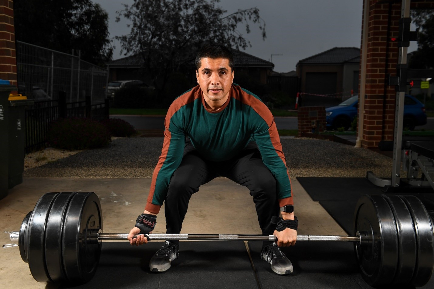 Man crouchs to pick up weights