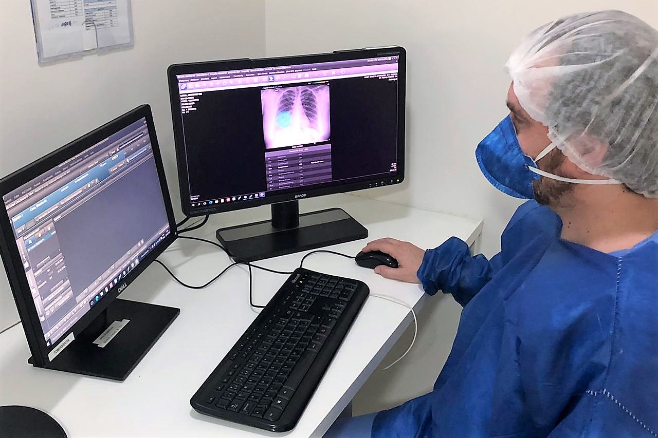 A man using a computer wearing medical protection gear