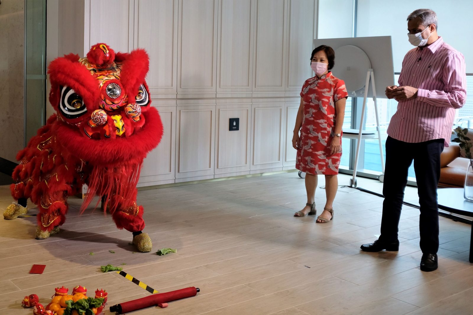 Two people watch a Chines lion dance