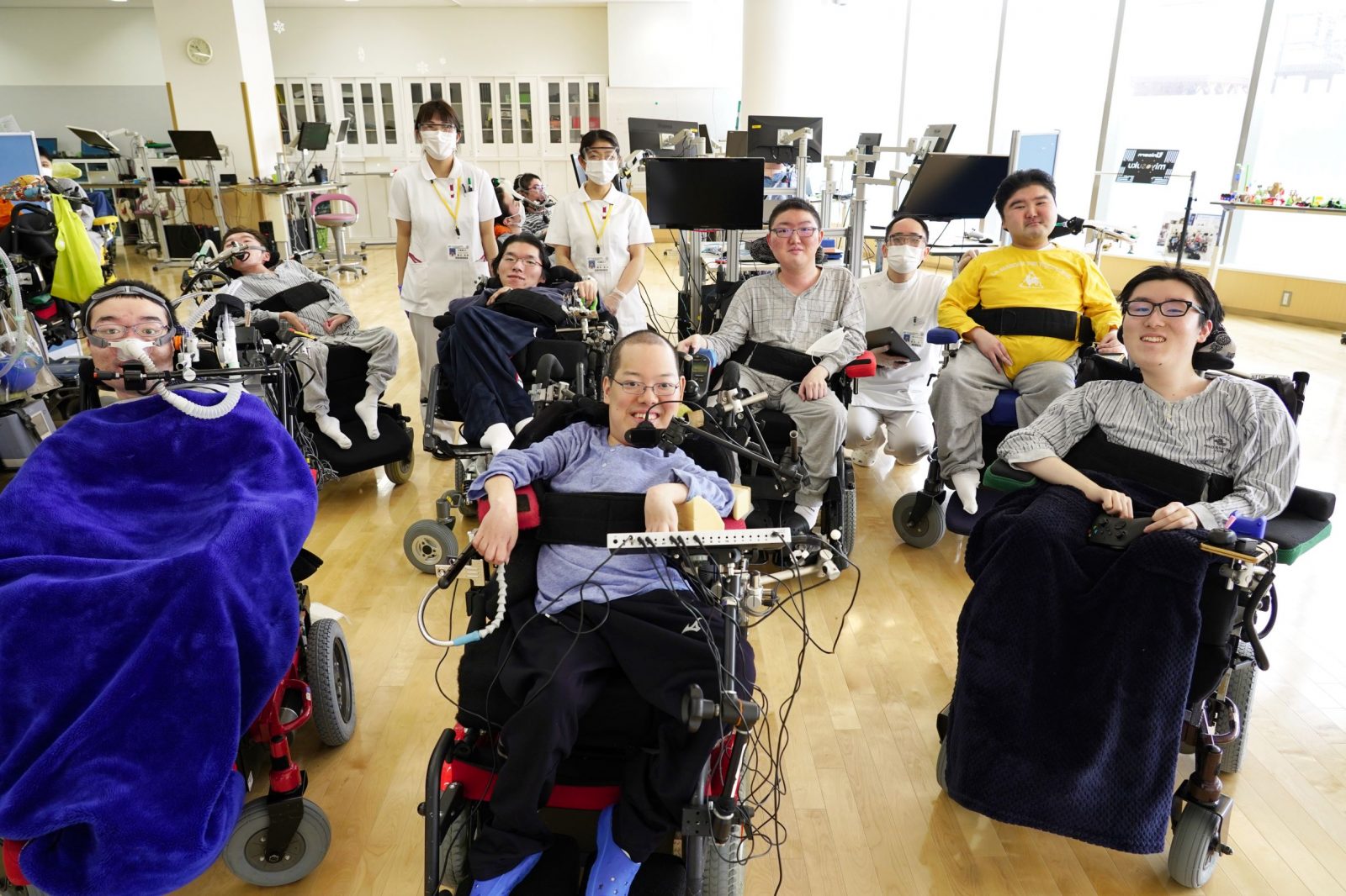A group of smiling people in wheelchairs