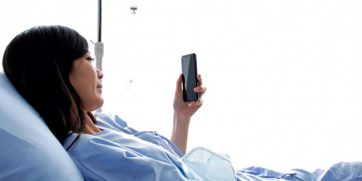 Woman in a hospital bed using a cellphone