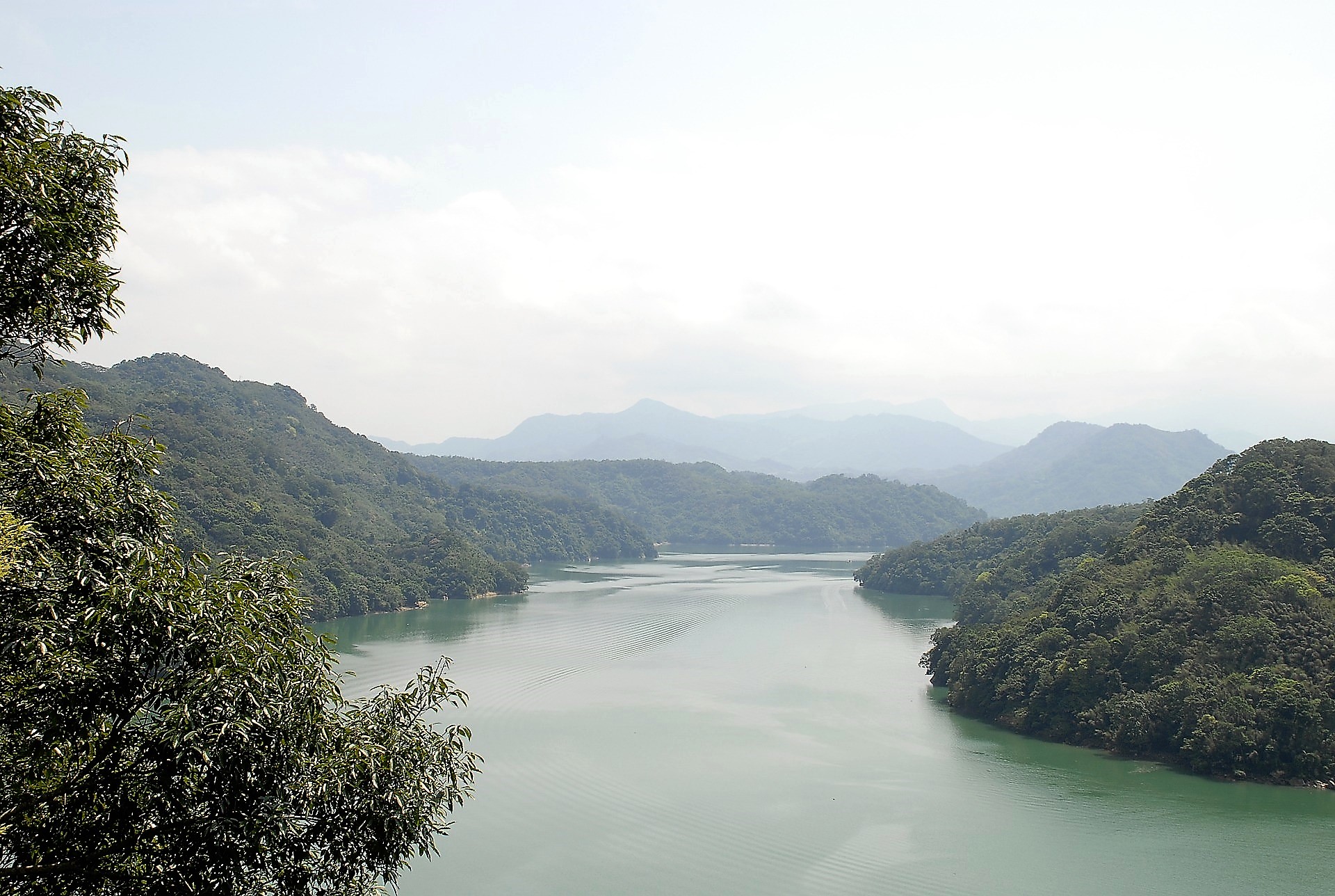 Taiwan's Shihmen Reservoir surrounded by wooded hills.