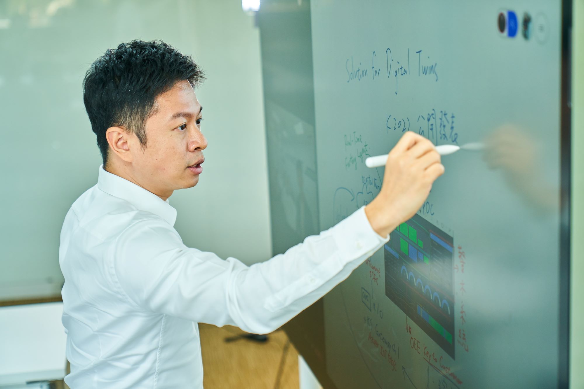 Jim Chen shown writing on a whiteboard. 