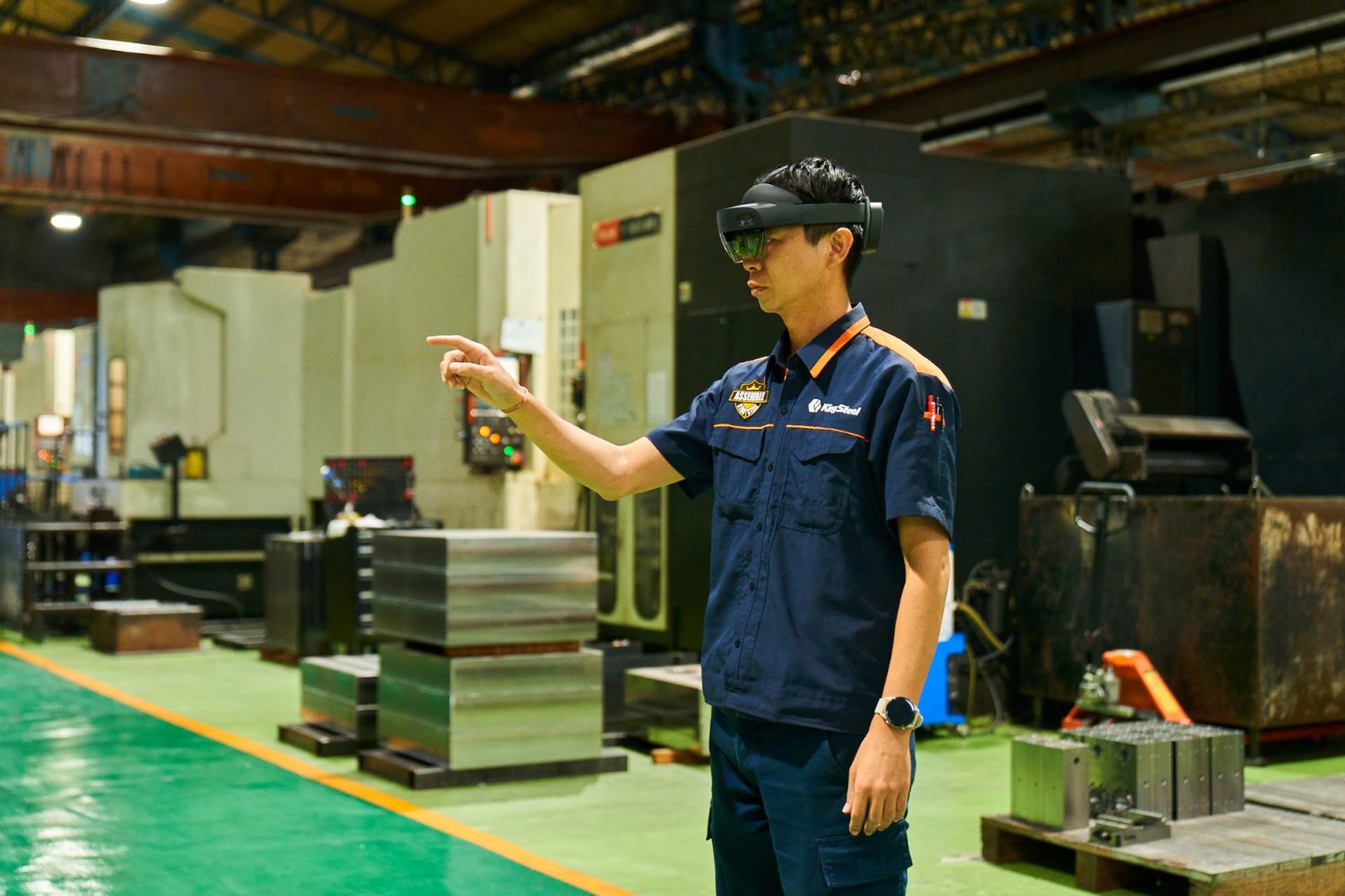King Steel worker on the factory floor of King Steel using is wearing a mixed reality headset.