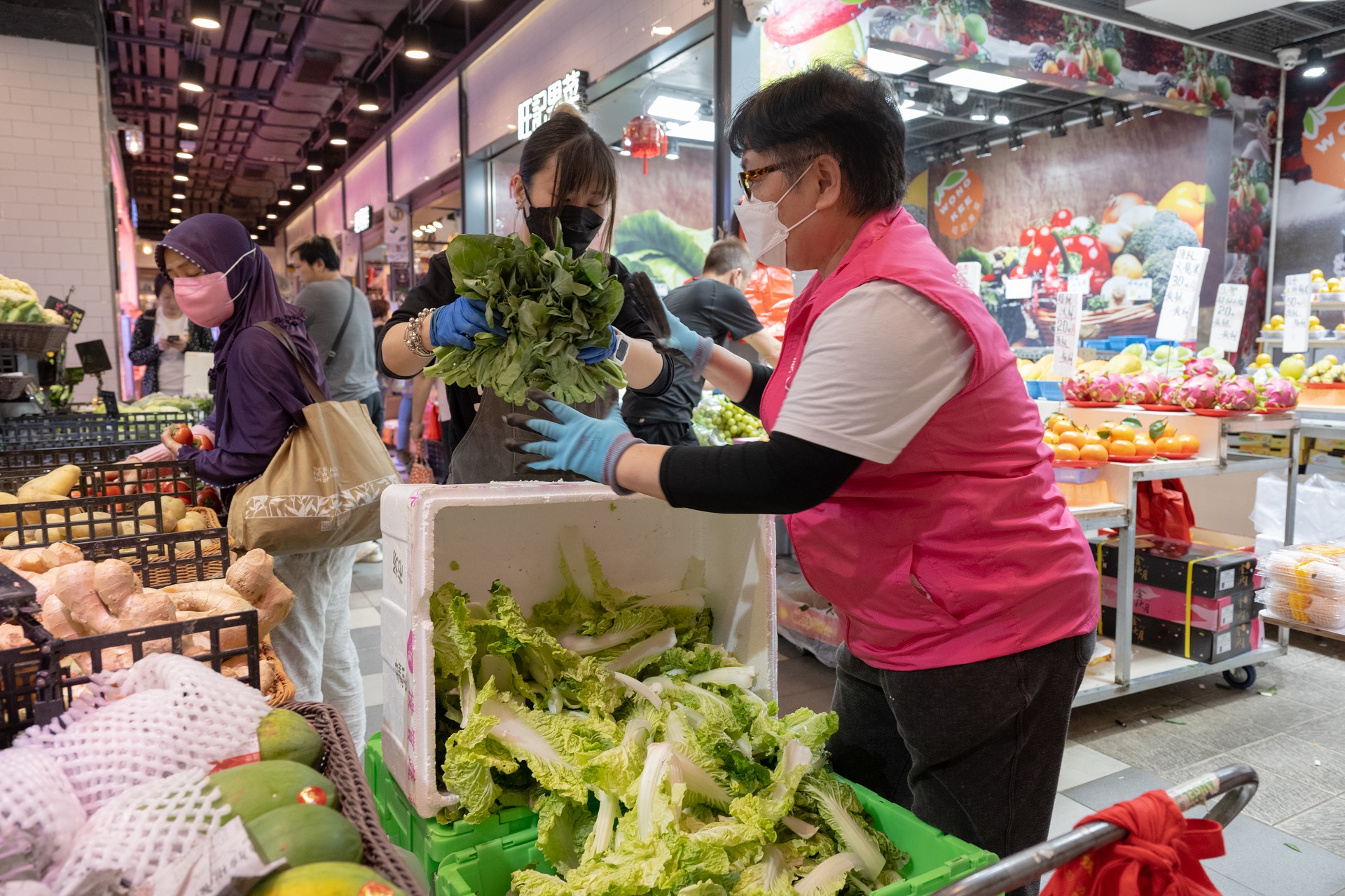 People handle vegetables in a market.
