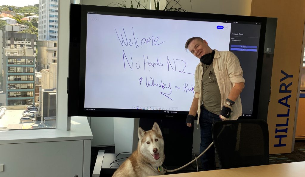 Man standing in front of smart screen with dog