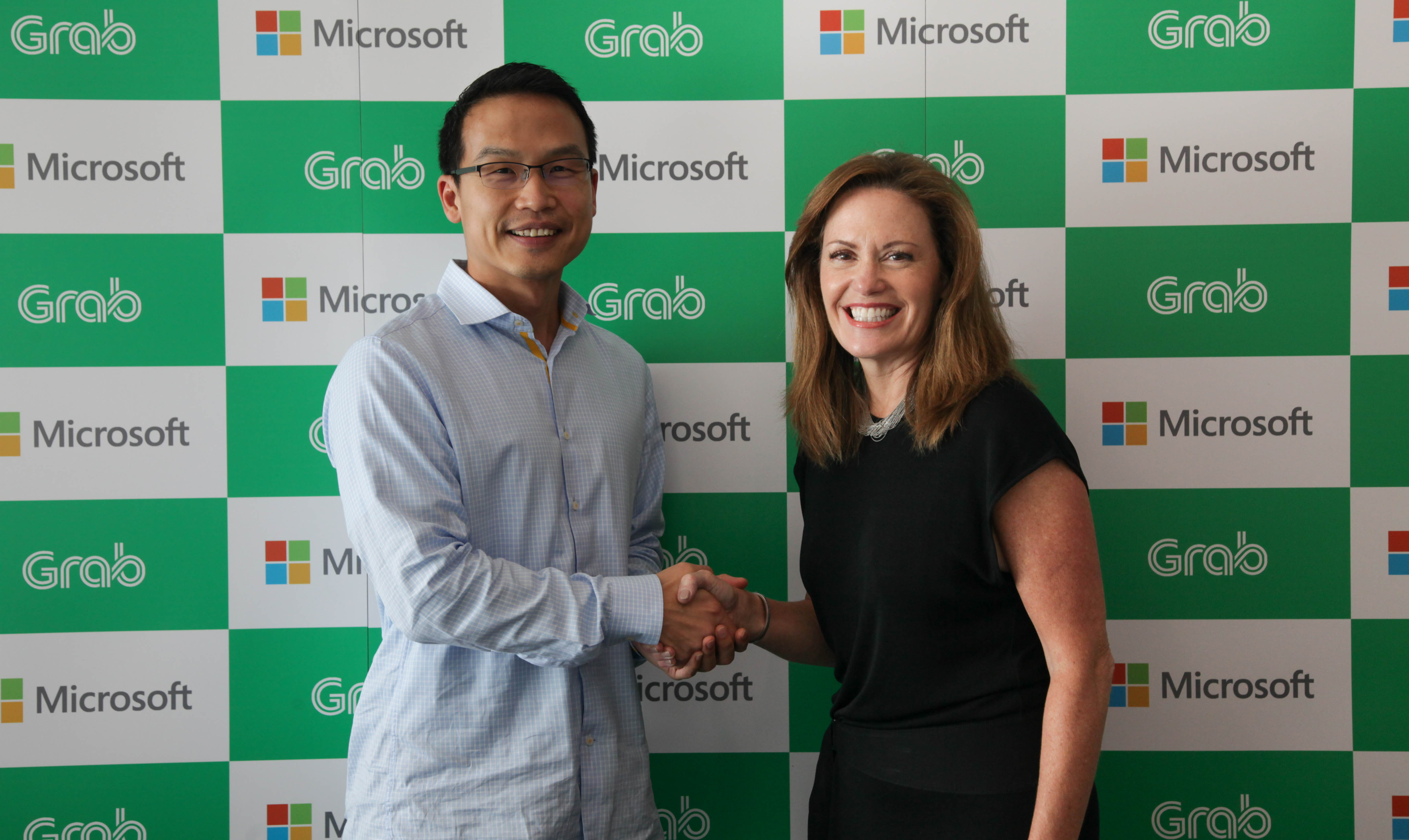 Ming Maa, president of Grab & Peggy Johnson, executive vice president, Microsoft shaking hands