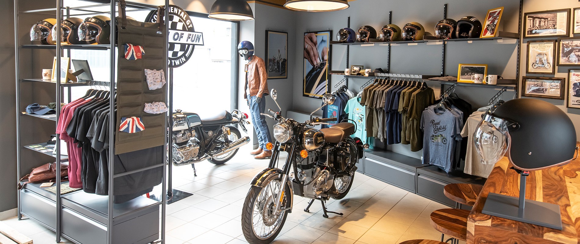 A Royal Enfield showroom, with two bikes on display along with riding gear and other branded merchandise