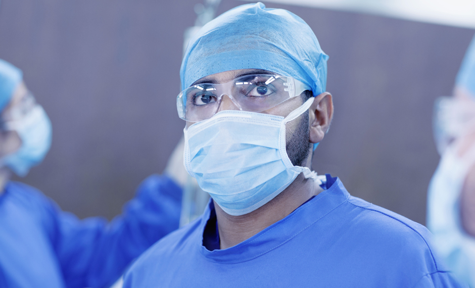 A doctor wearing a face mask looking at the camera
