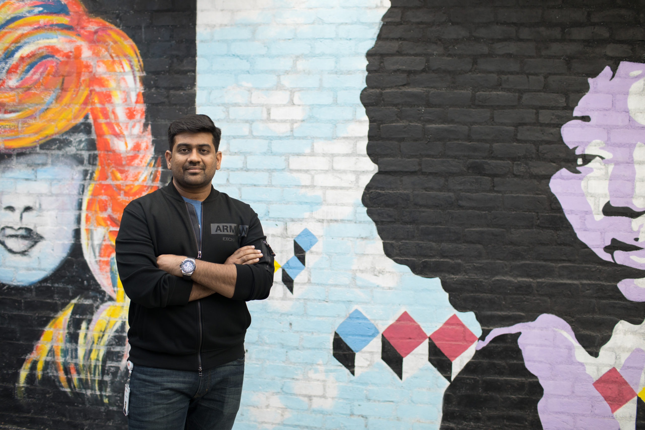 Amar Nagaram standing in front of a wall with a mural