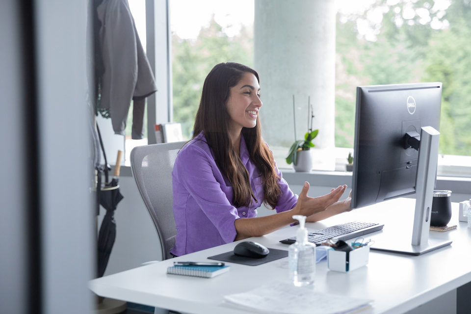 A female employee on a video call on a PC, at her workstation