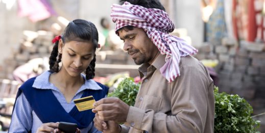 a photo of a man holding a credit card and a girl using a phone to make an online transaction