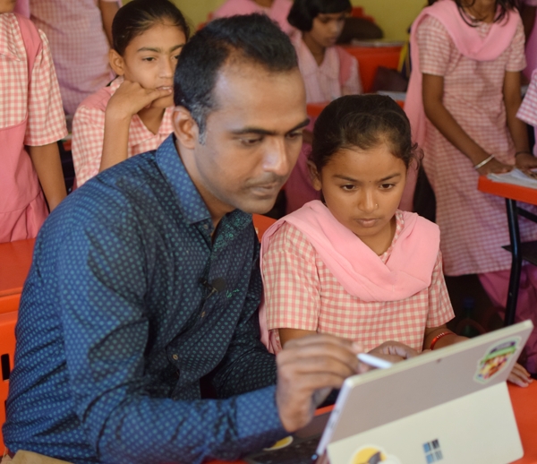 Photo of a male teacher teaching students on a laptop
