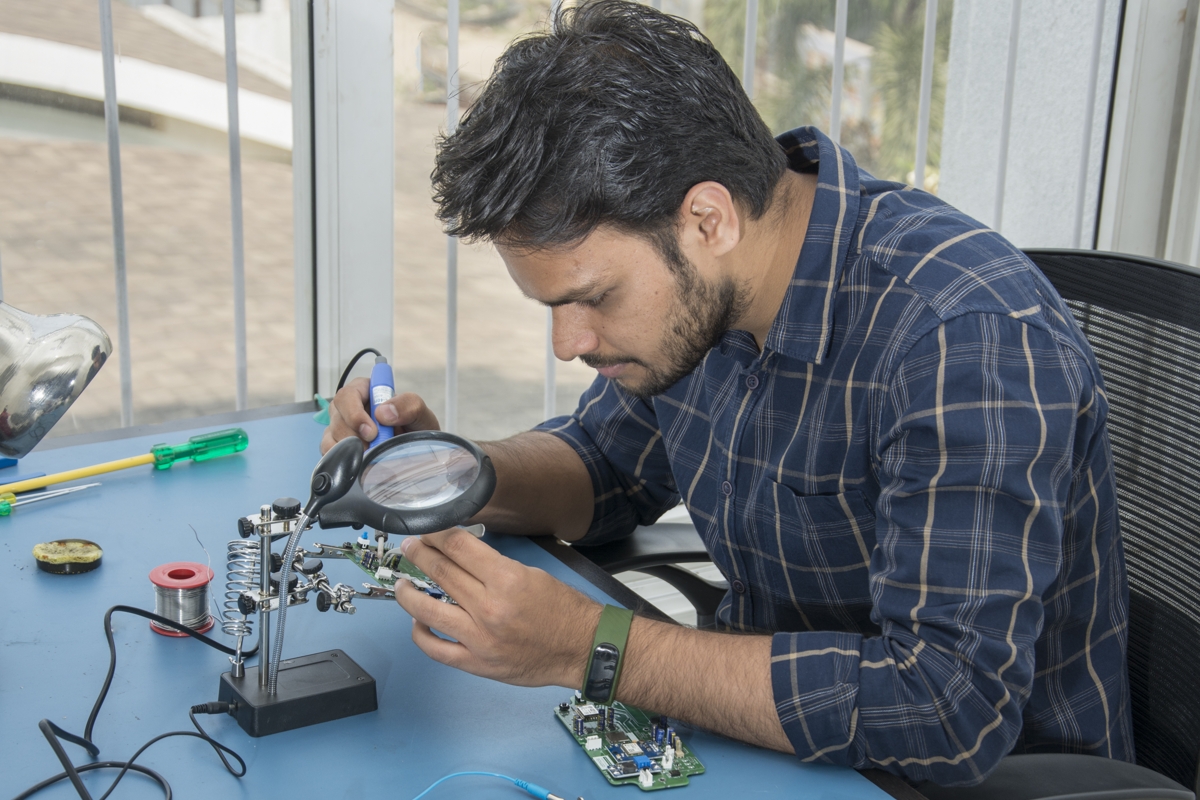 Photo of a man using tools to repair a circuit board