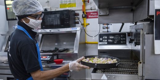 Photo of a man preparing pizza in a kitchen
