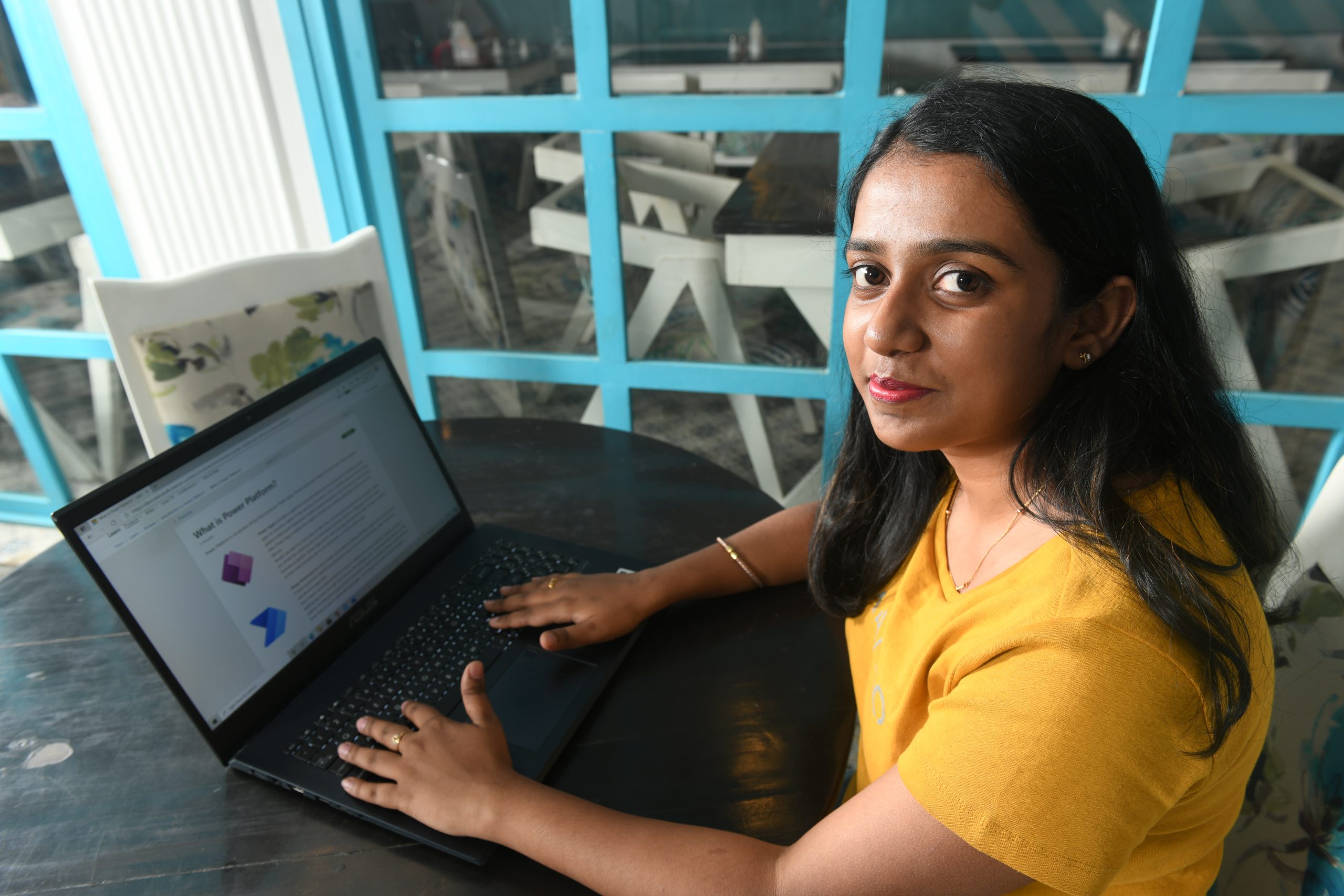 Photo of a woman on a laptop smiling at the camera