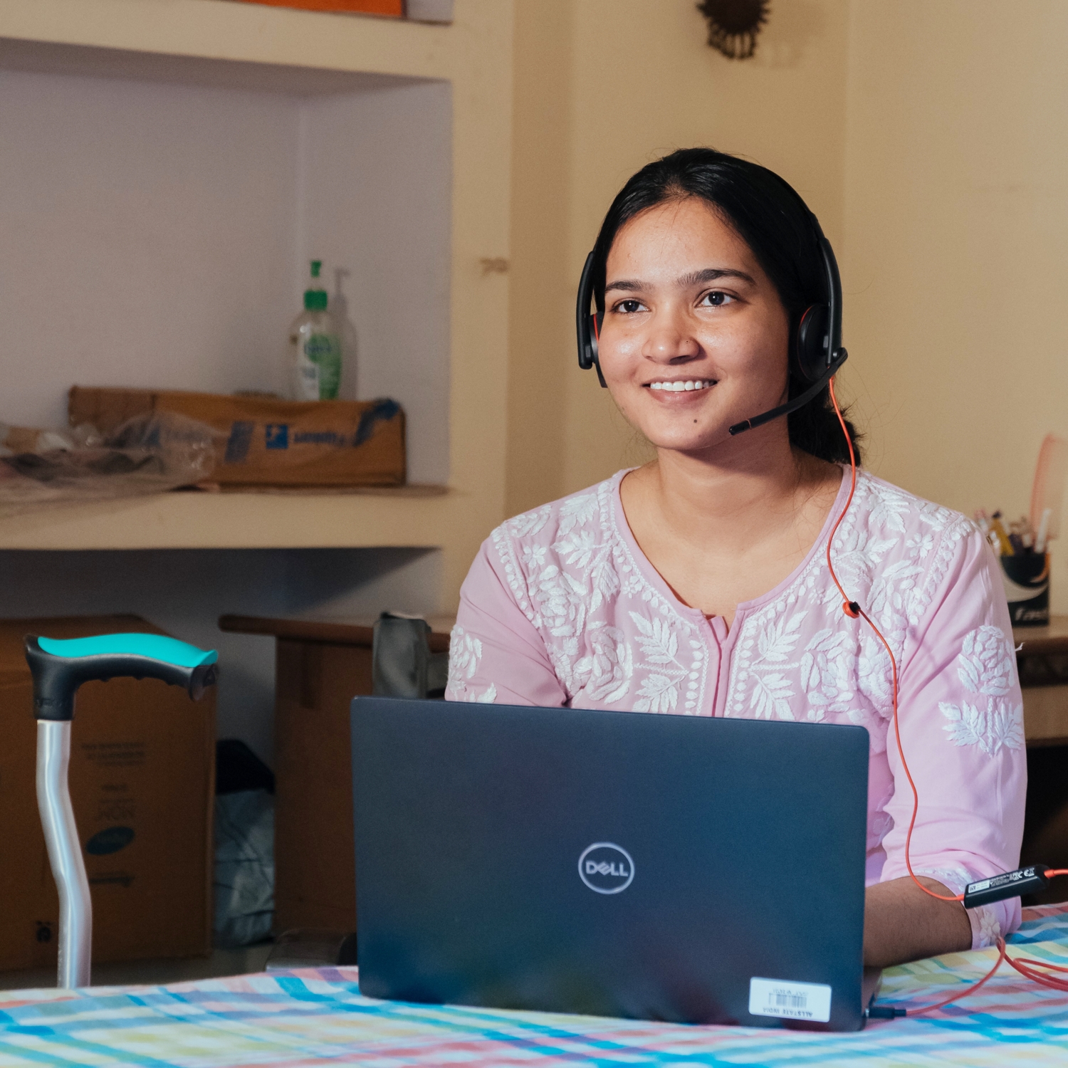 Photo of a woman smiling while working on a laptop