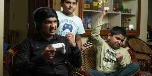 a photo of three boys celebrating while playing an xbox game
