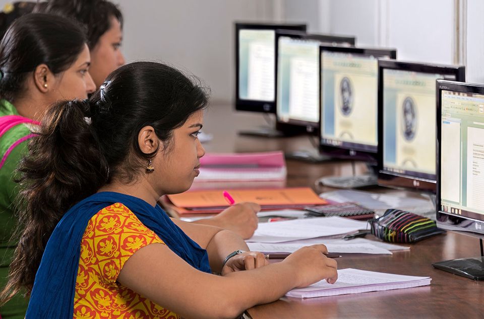 a photo of young women working on PCs