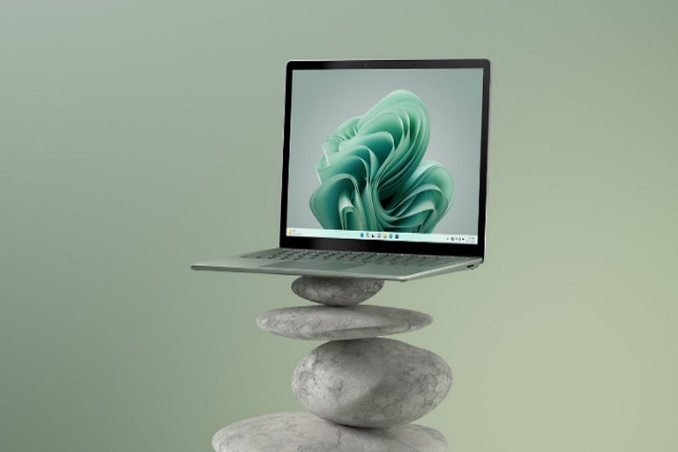 a photo of laptop 5 perched upon a stack of large pebbles