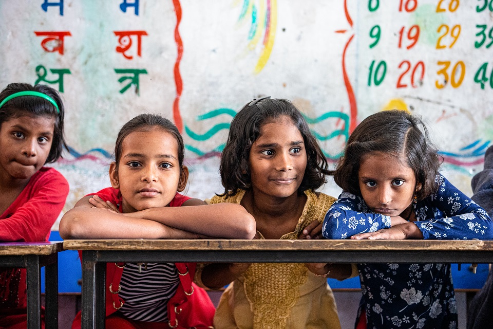 a photo of four girls in a classroom
