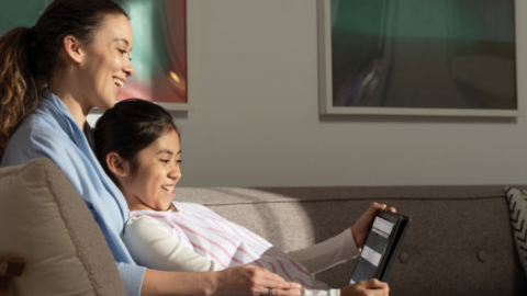 mom and child smiling while looking at tablet