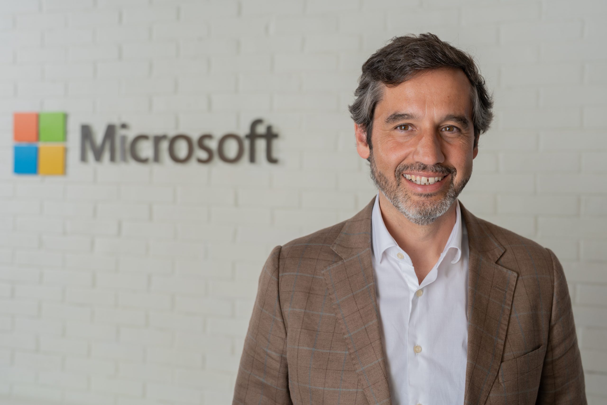 Picture of Pedro Pinto Lourenço, smiling at the camera, with Microsoft logo in the background