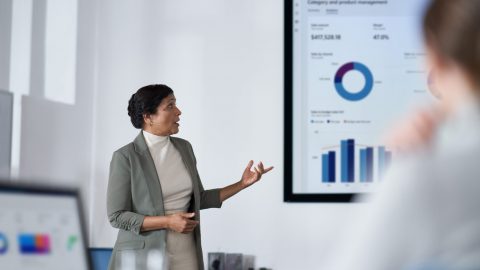 Picture of a woman doing a presentation with graphs portrait