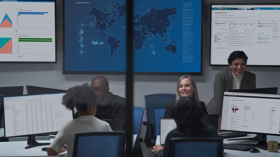 Image of a cybersecurity center with people and computer screens
